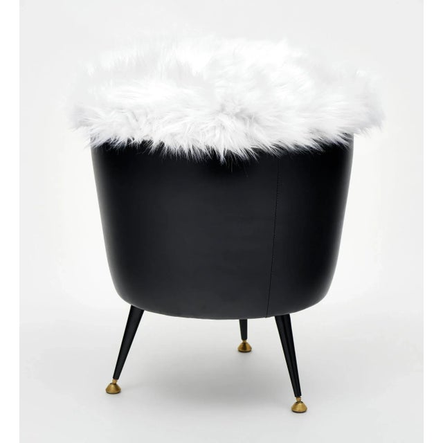 Single stool from mid-century Italy featuring black leather and newly upholstered white shag seat. Three flared legs...