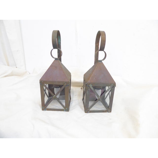 This pair of weathered copper lantern sconces have traces of verdigris appearing and measure 15.25"H x 5"W x 6"D. They...