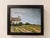 This oil on panel artwork depicts a quaint church nestled in a vibrant landscape, suggesting a serene escape. The soft,...