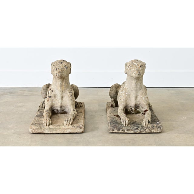 A pair of early to mid-20th century English Whippet dogs (resembling greyhounds) made of cast, reconstituted stone that...