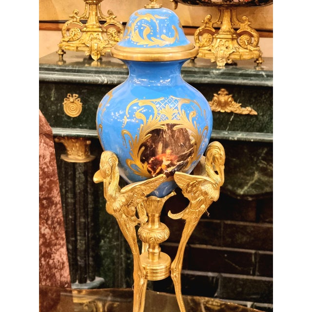 This elegant French-style porcelain vase features a rich blue finish accented with intricate gold leaf detailing, creating...