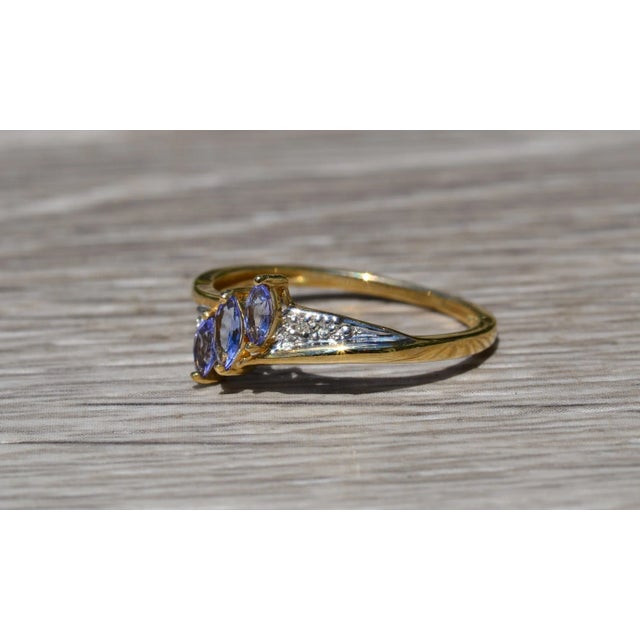 The Aubrieta Ladies Simple Yellow Gold Tanzanite and Diamond Ring. Crafted in durable yellow gold, this ladies ring...