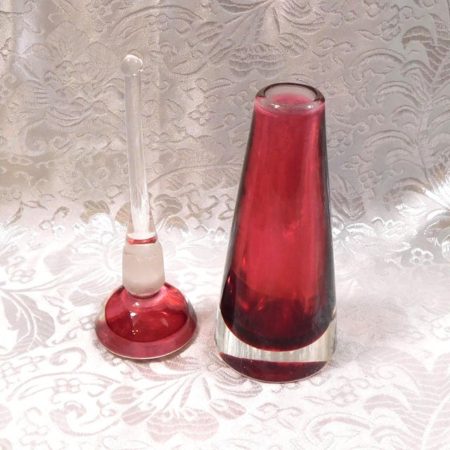 This is a pink art glass perfume bottle that has no tags or markings. The bottle is cone shaped dark pink cased in clear...