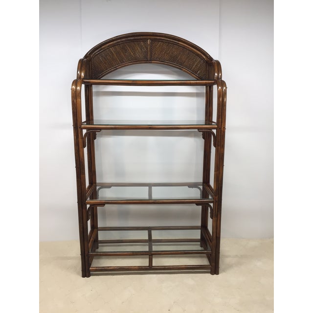 Very nice Genuine Ratan etagere with glass shelves. Piece has a wonderful almost fan style arched top with glass shelves....