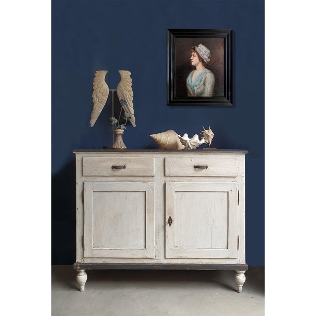 An antique sideboard in a provincial style, likely made of pine or fir. The piece features two spacious drawers at the top...