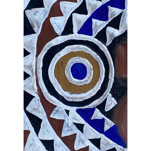 Superb plank mask in round shape depicting a face and a long nose circular concentric eyes, and open round mouth. Known as...