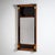 Elegant wall mirror in a slim, rectangular format, crafted around 1810. The frame is veneered in warm cherrywood and...