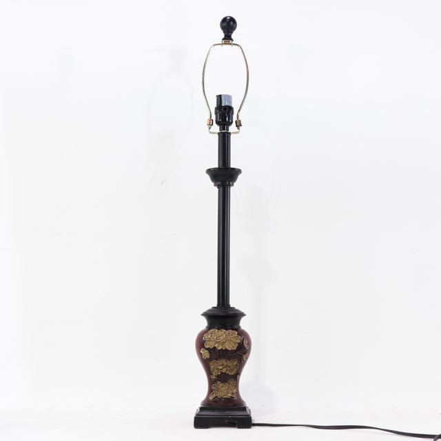 This dramatic pair of matching vintage lamps features a long, slender black stem rising from a decorative urn-shaped base....