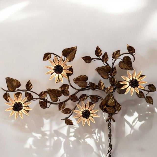 A large vintage Italian gilt-tole wall sconce composed as a radiant spray of sunflowers, leaves and illuminated flower...
