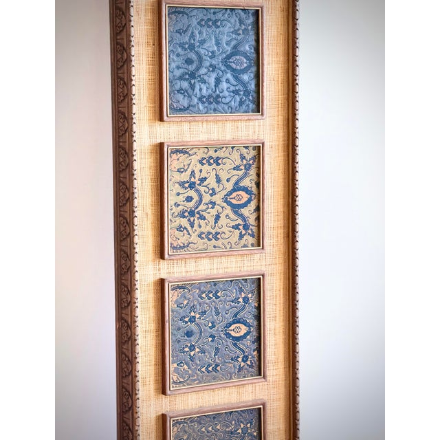 Tall framed art featuring individually inset batik patterned squares arranged in a vertical composition on a woven...
