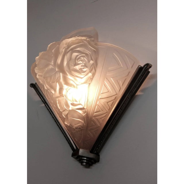 A pair of French Art Deco wall sconces by the French artist " Verdun " Molded clear frosted glass shades decorated with...