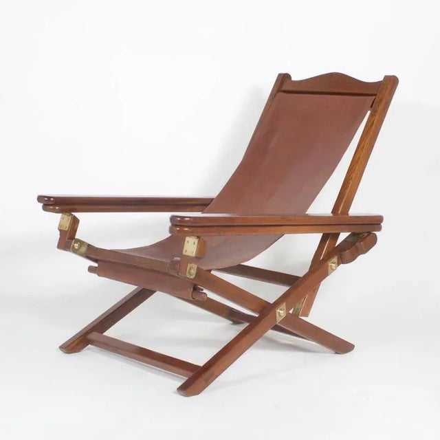 Handsome pair of Mid-Century mahogany folding chairs. The seats are soft, brown leather sling style with the backs being...
