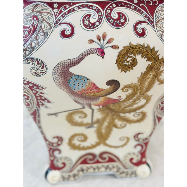 This is a decorative ceramic garden stool with a square, slightly scalloped top and a richly detailed design. It features...