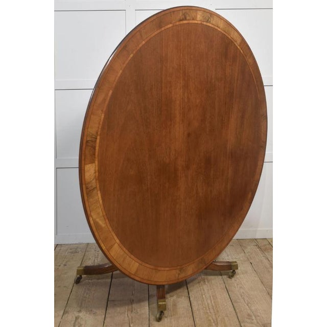 This beautifully crafted Georgian-style round dining table features a rich mahogany top framed by a striking rosewood...