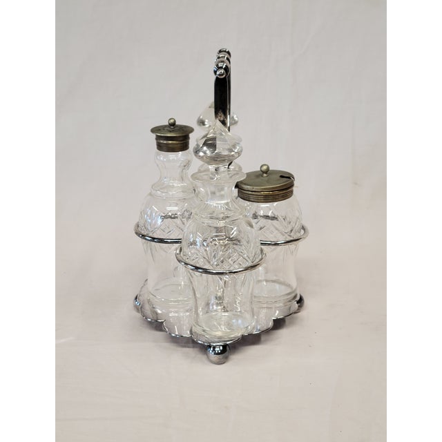 This sweet antique circa 1900 silverplate and glass four round bottle cruet set features distinctive faceted stoppers in...