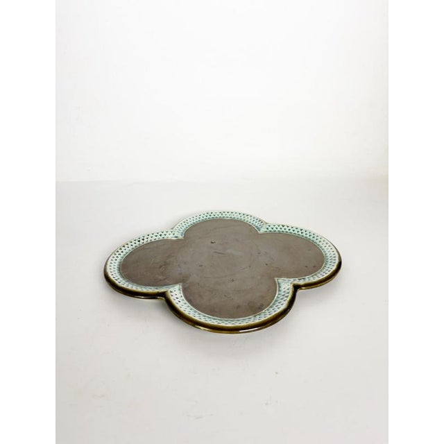 Decorative ceramic dish featuring an elegant quatrefoil (clover-shaped) silhouette with a soft cecidon-green glazed border...