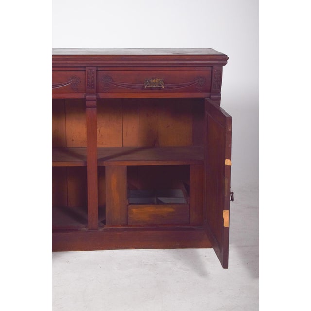 Sideboard with two different doors. In dark wood with richly detailed carvings on the front doors. Two large lower doors...