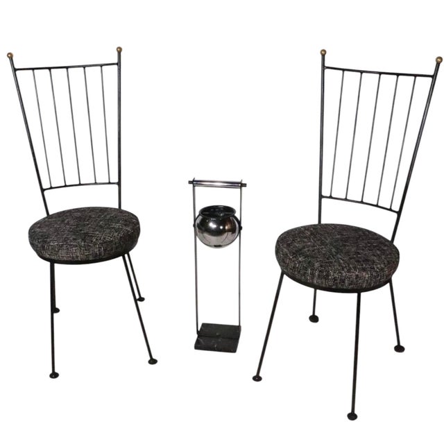 Exceptional pair of wrought iron and brass dining height side chairs executed in wrought iron, brass and upholstery. These...