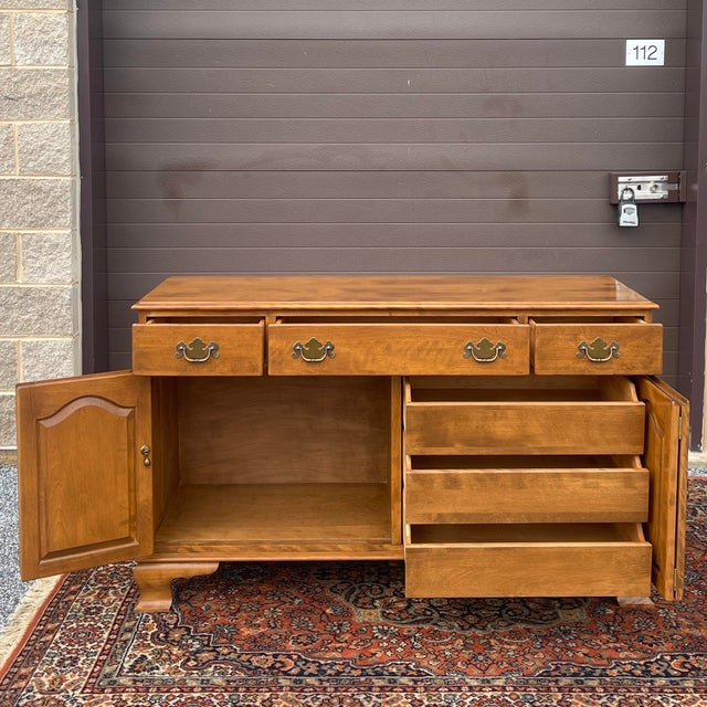 A vintage Ethan Allen Heirloom collection Traditional solid maple buffet or sideboard having the drawers above two sets of...