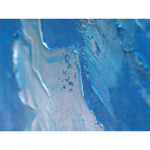 This artwork depicts an astronaut standing in a vast, tranquil sea, holding a whimsical unicorn pool float. The contrast...