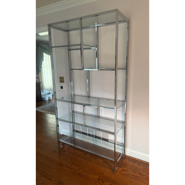Iconic Milo Baughman Chrome and Glass Étagère, c. 1970s. This timeless mid-century modern shelving unit features chrome...