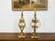 A pair of French gilt metal table lamps from the mid 20th century, with scrolling effects, fleurs de lys and lucite bases....