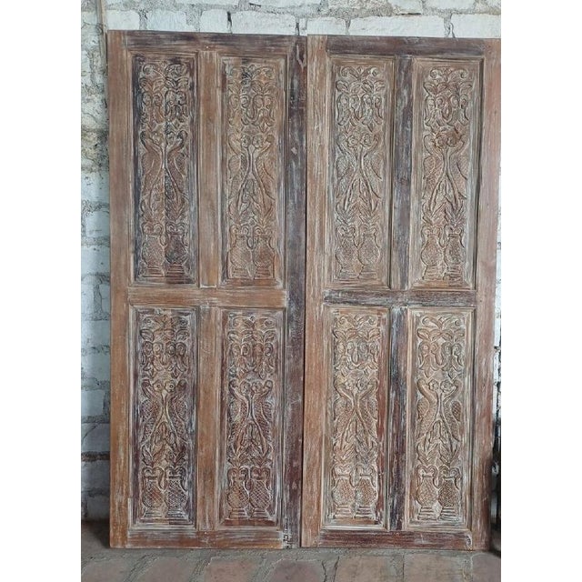 This exquisite antique sliding barn door showcases intricate hand-carved birds and floral patterns, beautifully...