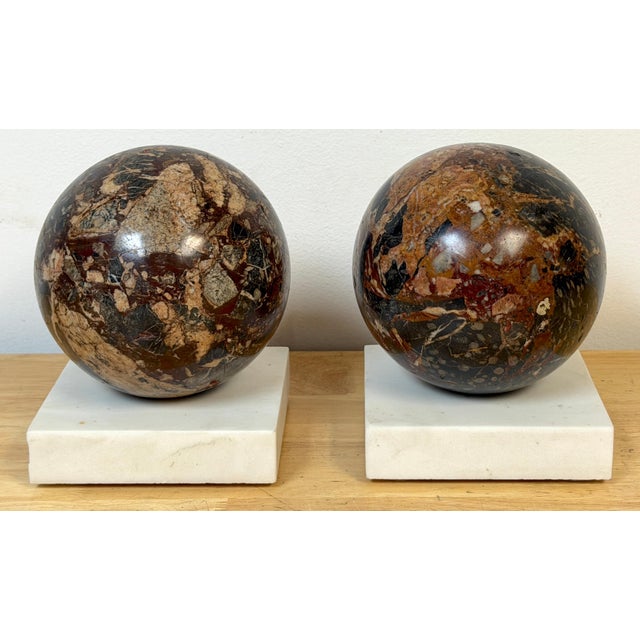 This pair of Italian Grand Tour-style brecciated specimen marble spheres on Carrara marble bases showcases the timeless...