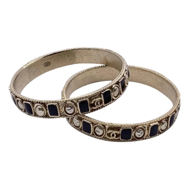 Two 1990s Iconic Gold Plated Metal and Black Enamel Bangle Bracelets by Chanel For Sale