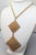 1967 goldtone two diamond shaped woven pendants on the chain necklace with spring ring clasp. Marked "NAPIER ©" on the...