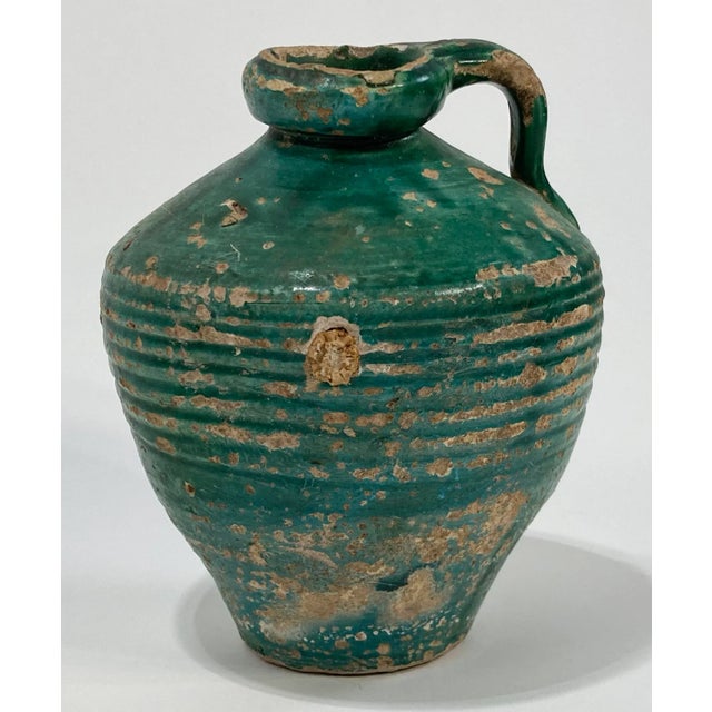 Antique primitive terra cotta jug with handle featuring chippy medium green glaze. Once a common piece of pottery used...