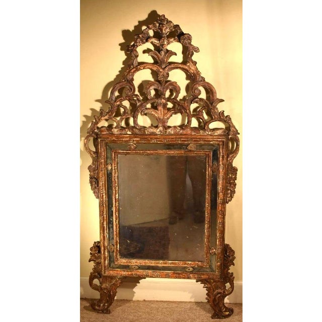 Large Italian rococo carved mirror of the 18th century, now in an old worn and well patinaed state. Pierced naturalistic...