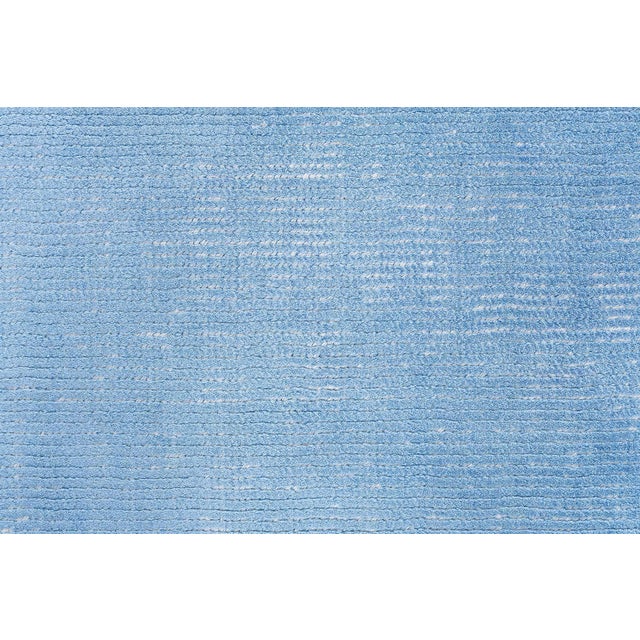 This spectacular Tibetan rug, measuring 11′0″ × 20′0″, is a statement in serenity and subtle grandeur. Crafted from a...