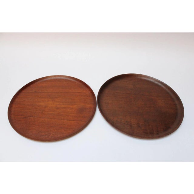 Set of four similar Swedish teak trays with curved edges, ca. 1960s. Slight variations in grain, color, and size...