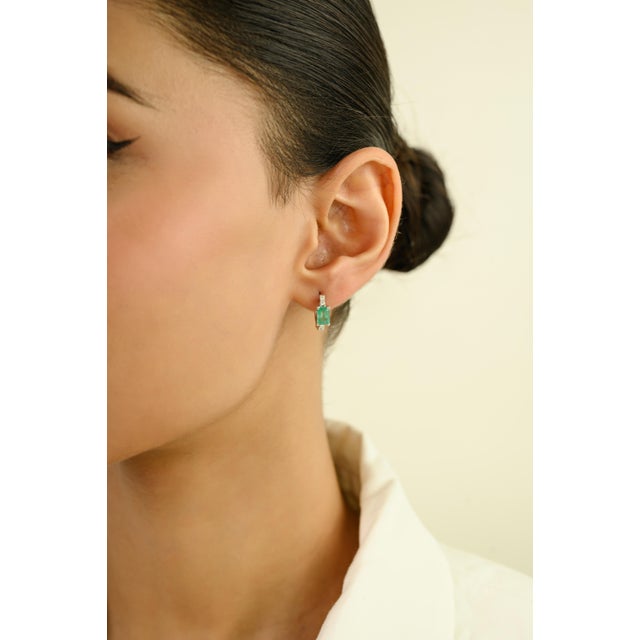 These elegant hoop earrings feature 2 natural emerald-cut emeralds totaling 1.3 carats, set in 14k white gold. Each...