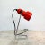 A vintage mid century red spotlight desk lamp by habitat. the lamp features a red plastic shade, raised on chromed wire...