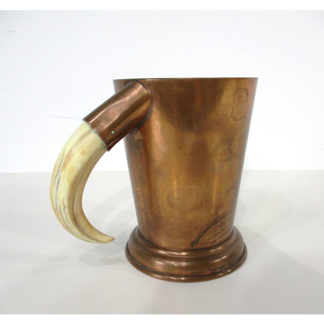 A hand-crafted beer or drink mug with stepped bottom and possibly a boar tusk handle made during the Mid-Century period....
