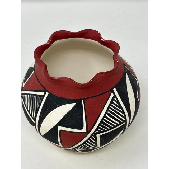 A beautifully hand-crafted Acoma Pueblo pottery jar signed “M. Chino,” featuring striking geometric decoration in...