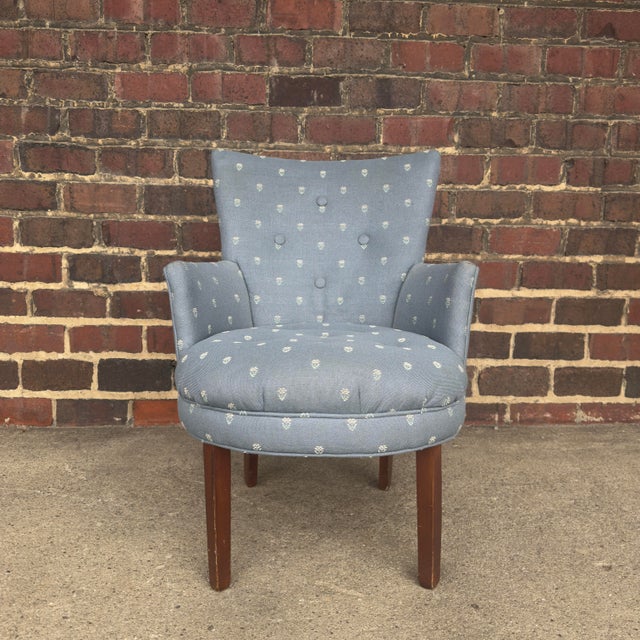 This petite armchair is upholstered in a dusty blue material with an embroidered pattern and button tufting. The back...