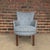 This petite armchair is upholstered in a dusty blue material with an embroidered pattern and button tufting. The back...