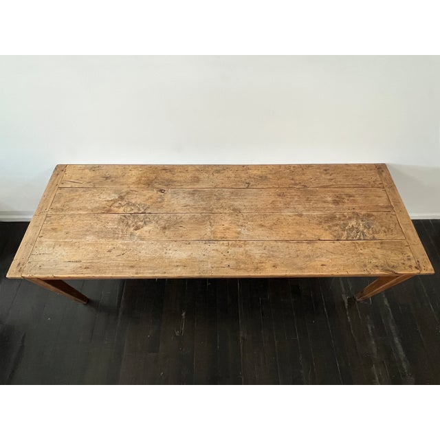 Antique French dining table crafted from solid applewood, featuring a small drawer with pull handle at one end. The...