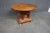 Modern accent table in Cherry with carved elephant base