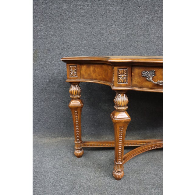 Drexel Heritage console table crafted in cherry and walnut with a gracefully shaped top above a serpentine apron fitted...