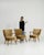 A set of three mid-century modern armchairs from Denmark, featuring wooden frames with upholstered seats and backs. The...