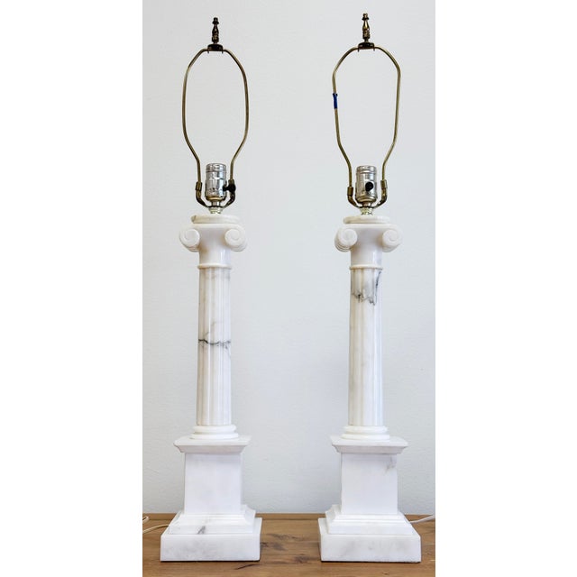Vintage pair of Neo-Classical style marble column table lamps featuring simple and stunning carvings to veined white and...