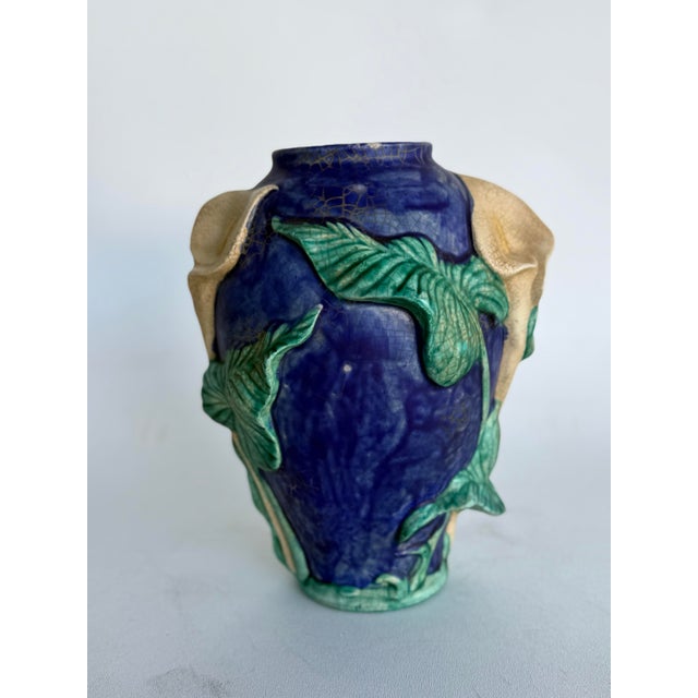 Vintage art pottery vase, produced in the early 20th century by American Rookwood Pottery. It features a dark blue glaze...