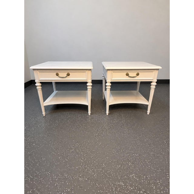 Exceptional matching pair of Neoclassical nightstands/end tables by Henredon Fine Furniture. These tables blend the...