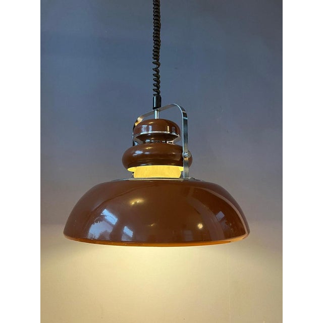 Vintage brown space age age pendant lamp by Anvia. The lamp is beautifully layered with brown parts and chrome parts. The...
