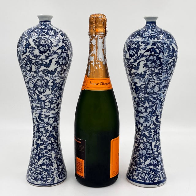 Vintage pair of Chinoiserie blue and white 12.5" tall slender dragon vases. The unusual shape resembles a reverse gourd...