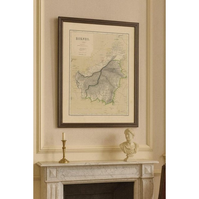 This decorative antique map depicts the island of Borneo in full during the late Dutch colonial period, showing the vast...